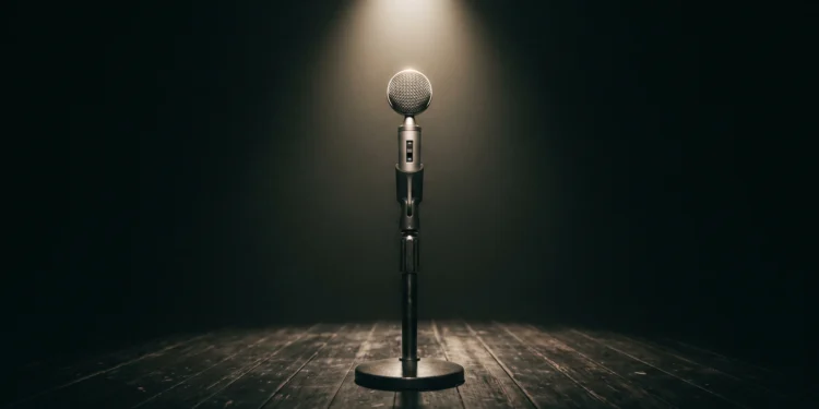 A microphone on a stage under a spotlight