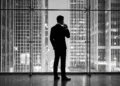 A minimalist silhouette of a man in a suit against a modern architectural background.